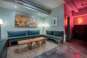 Una sala moderna con un sofá seccional, una mesa de centro y obras de arte en las paredes.