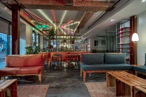 A modern interior with seating, a bar area, and a view through large windows.