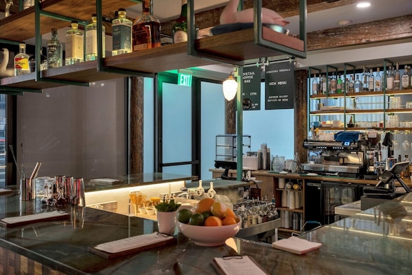 A bar area with a glass counter, bottles, and a menu board.