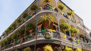 En byggnad med flera våningar, där balkongerna är prydda med växter och blommor.