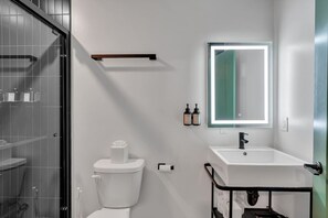 Un bagno moderno con servizi igienici, lavandino e specchio.