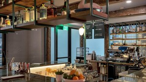 Un espace bar avec un comptoir en verre, des bouteilles et un tableau affichant le menu.