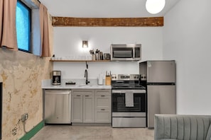 A compact kitchen with a dishwasher, stove, microwave, and refrigerator. - 3 Bedroom Apartment, French Quarter, Steps to Saenger and Canal Street (New Orleans)