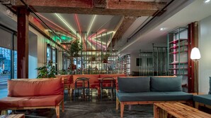 Ein modernes Interieur mit Sitzgelegenheiten, einer Bar und Blick durch große Fenster.