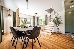 Ein stilvoller Essbereich mit Holztisch und -stühlen, einer Treppe und einem Topfpflanzen.