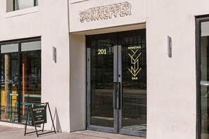 A storefront with a sign reading 'DOVETAIL BAR' and a glass door with the number '201'.