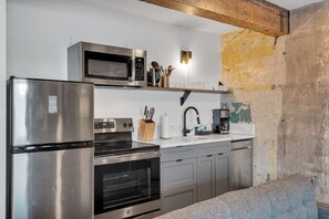 A kitchen with stainless steel appliances, a microwave, oven, and a coffee maker.