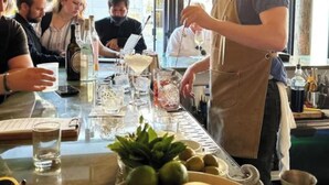 A bar area with a bartender preparing drinks, a table with glasses and bottles, and a window with a view. - 3 Bedroom Apartment, French Quarter, Saenger Next Door, Streetcar, Pool (New Orleans)