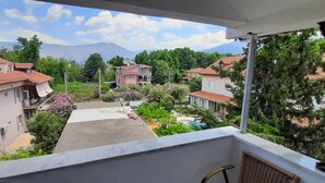 A residential area with houses, a swimming pool, and mountains in the background. - TANGO PANSIYON (Koycegiz)