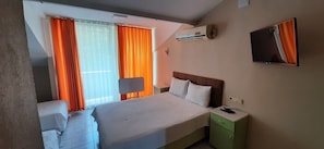 Une chambre d’hôtel équipée d’un lit, d’une table de chevet, d’un téléviseur et d’un appareil de climatisation.