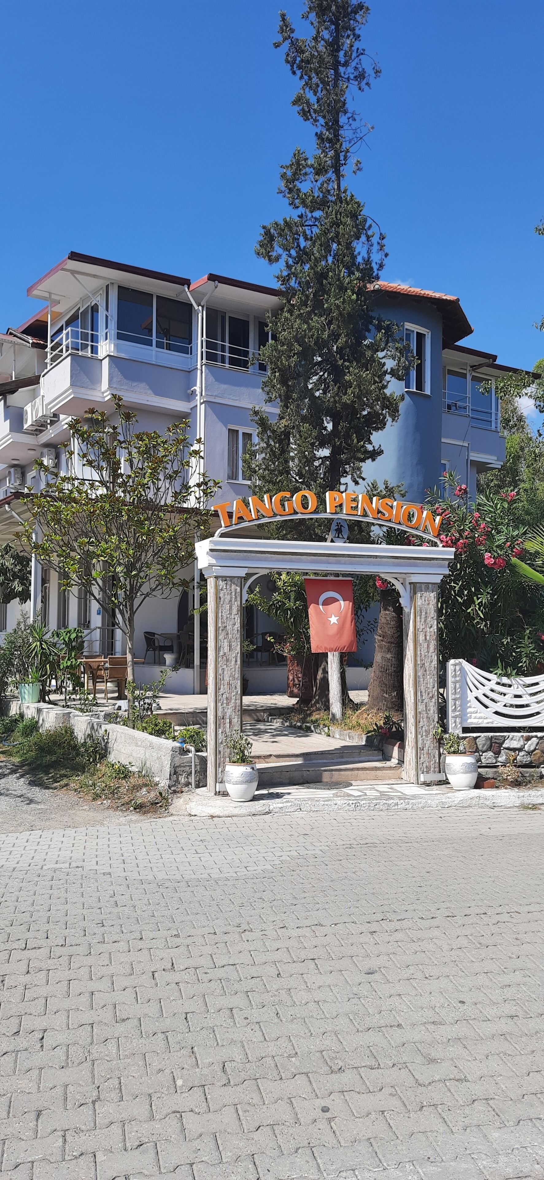 A building with a sign reading 'TANGO PENSION' and a flag.