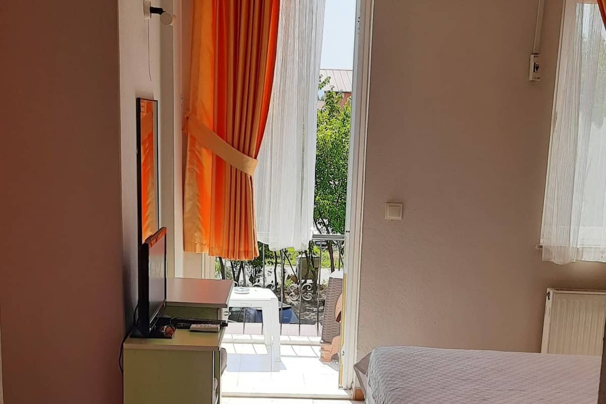 Habitación de hotel con dos camas, un escritorio, una silla y vistas al exterior.