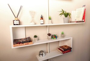 A bookshelf with books, a Rubik's cube, and small plants.