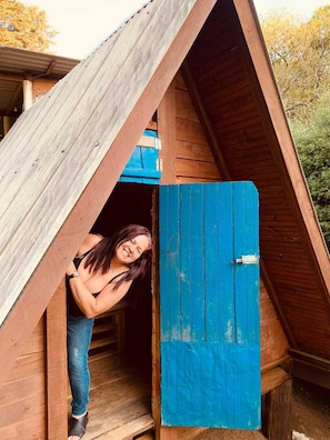 A wooden structure with a blue door and a sloped roof. - Camping Monte Verde  (Monte Verde)