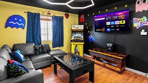 Ein Wohnzimmer mit einer Couch, einem Couchtisch und einem Fernseher, der eine Spieloberfläche zeigt.