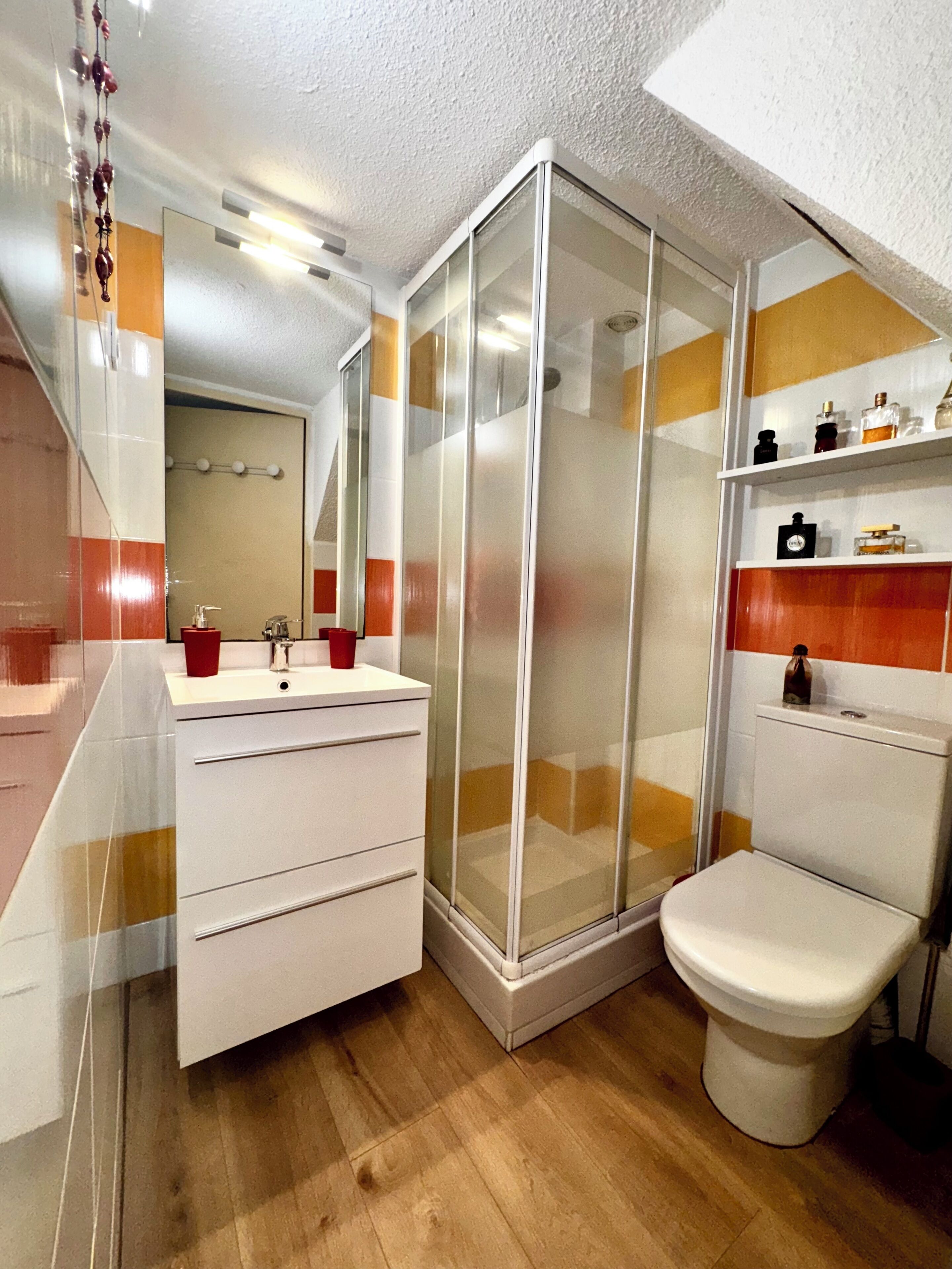 A bathroom with a shower, toilet, and sink.