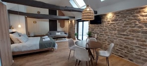 Um interior moderno com cama, sofá, mesa de jantar e cadeiras.