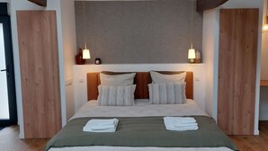 A bedroom with a bed, bedside lamps, a desk, and a chair. - Le Clos de Squividan - L'Évasion (Ergué-Gabéric)