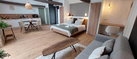 Un intérieur moderne comprenant un lit, un canapé, une table à manger et un coin cuisine.