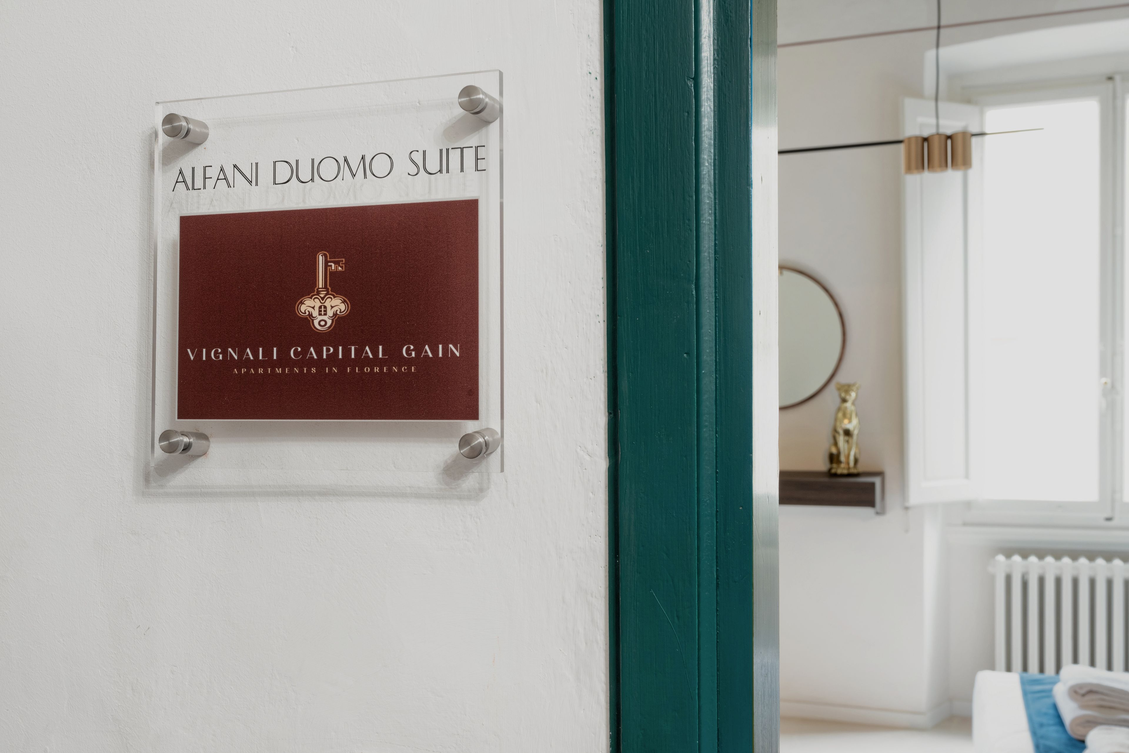 Een bordje voor de Alfani Duomo Suite in een hotel, dat aangeeft dat het deel uitmaakt van de Vignali Capital Gain appartementen in Florence.