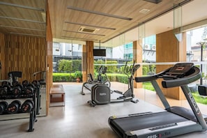 Ein modernes Fitnessstudio mit Laufbändern, Crosstrainern und Gewichten.