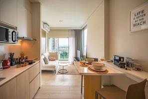 Eine moderne Küche mit Essbereich, einer Couch und Blick auf die Stadt.