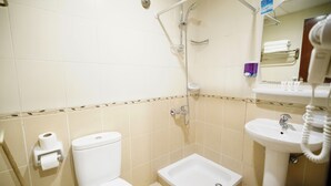 Ein Badezimmer mit Toilette, Bidet, Waschbecken und Dusche.