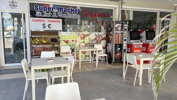 Un grand supermarché avec une enseigne « CAMBIO | CHANGE », une autre enseigne « Mercado » et un distributeur automatique de la marque « Cafe World ».