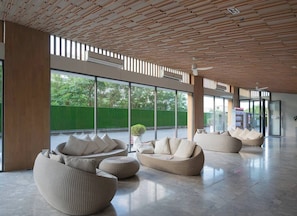 Eine großzügige Lobby mit moderner Einrichtung, großen Fenstern und einer Holzbalkendecke.