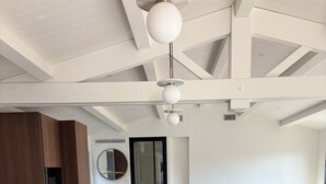 Cozinha moderna com uma ilha grande, armários de madeira e um tapete preto no balcão.