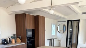 Uma cozinha moderna com ilha central, armários de madeira e um espaço de refeições com cadeiras.