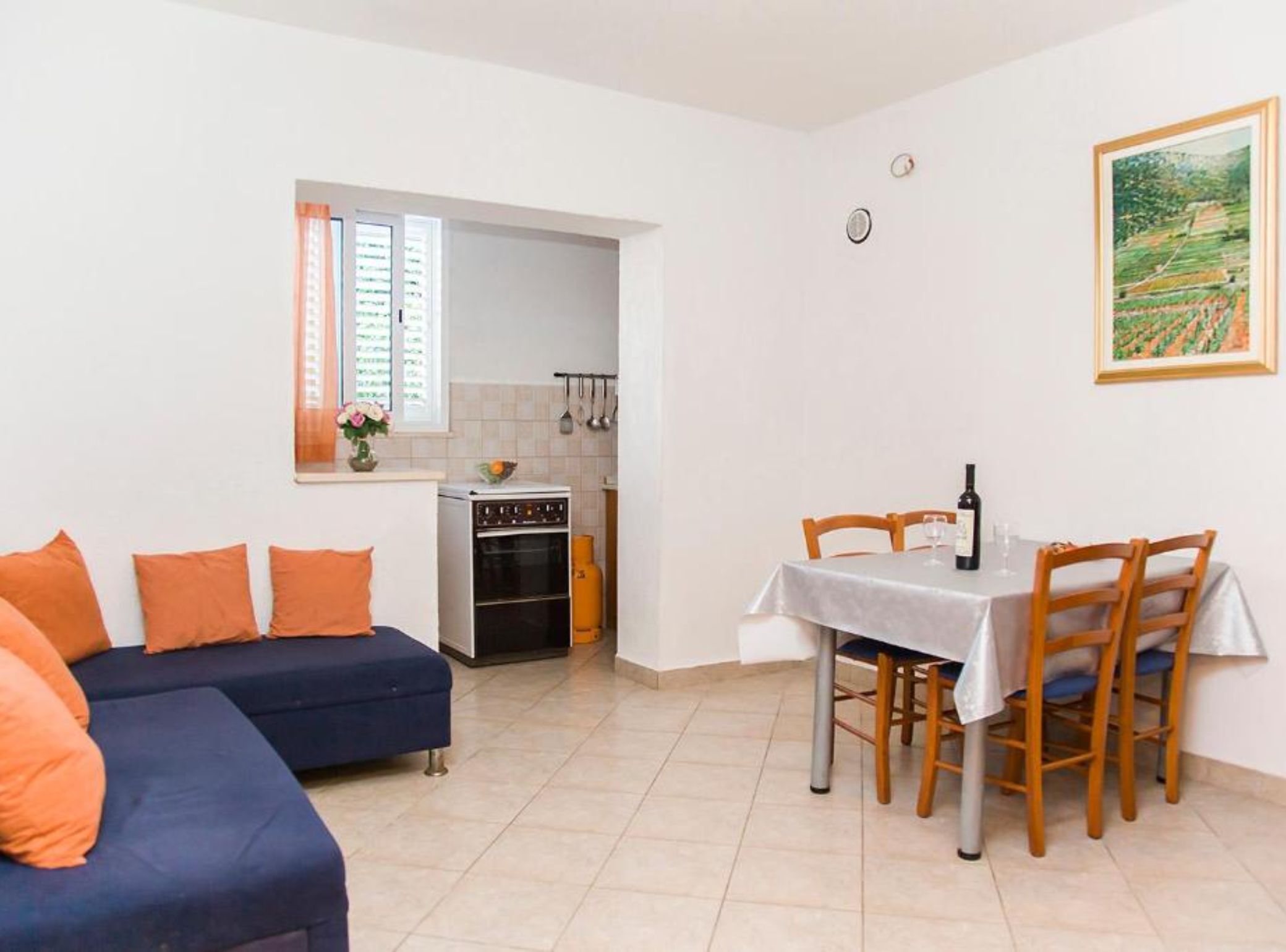 A living room with a sofa and a dining table with chairs.