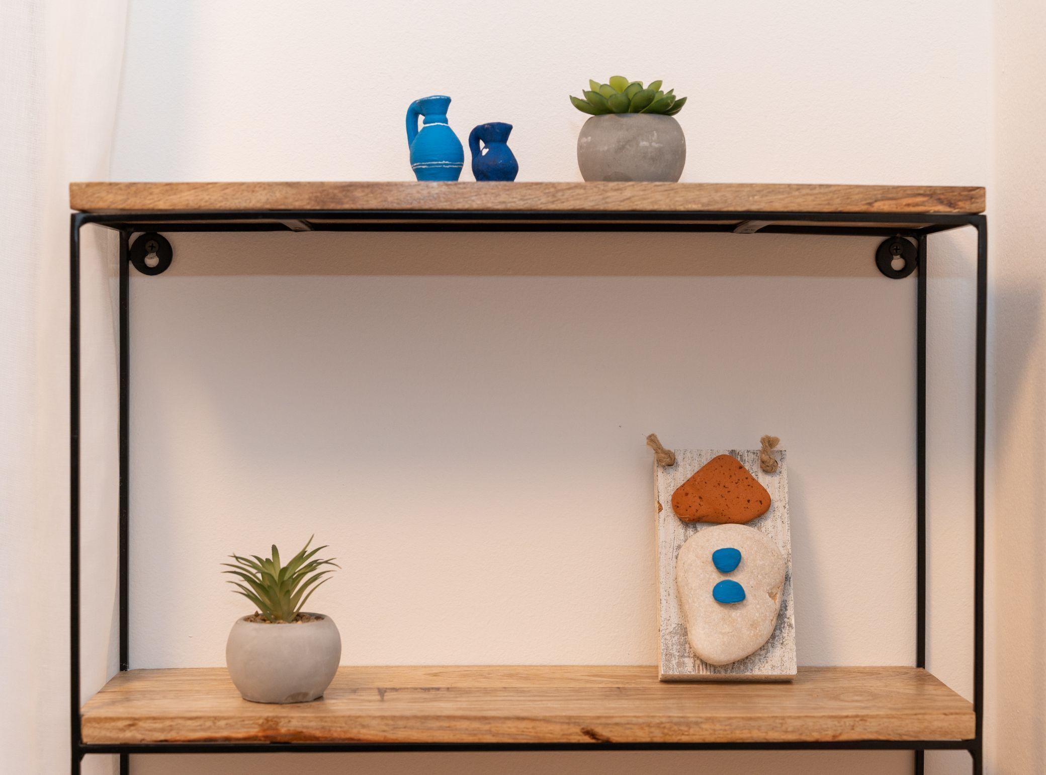 Une étagère avec deux plantes en pot et des objets décoratifs.