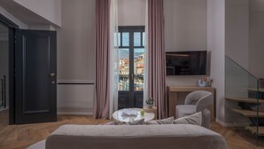 Un dormitorio moderno con cama, escritorio, silla, televisor y ventana con cortinas.