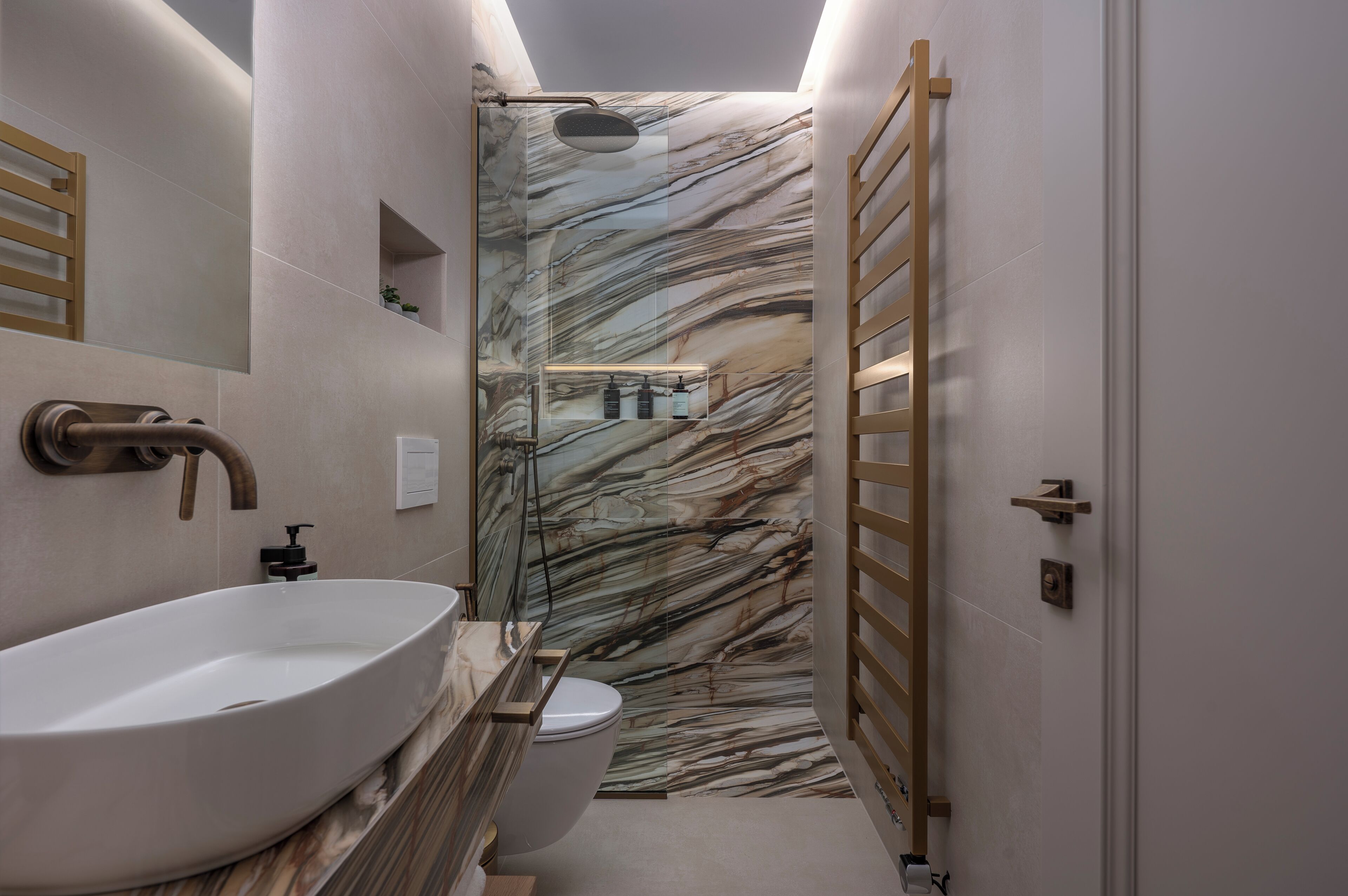 A modern bathroom with a large white sink, a shower, and a toilet.