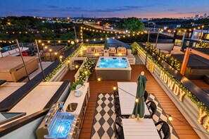 A rooftop terrace with a hot tub, outdoor seating, and string lights. - Stylish 4BR/4BA, Pool | Hot Tub & Views. 11 Beds! (Nashville)