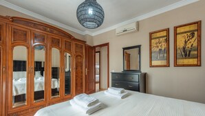 Ein Schlafzimmer mit einem großen Bett, einem Holzschrank und einem Spiegel.