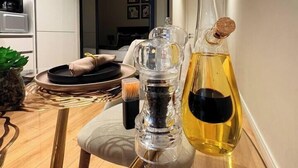A modern kitchen with a glass table, a wine bottle, and a candle holder. - Elite Skyline Suite, Ellipse, Waterfall City (Midrand)