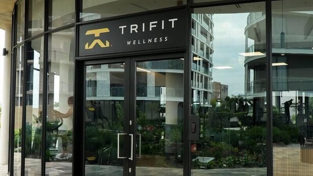 A modern building with a glass facade and a sign reading 'TRIPIT WELLNESS'. - Elite Skyline Suite, Ellipse, Waterfall City (Midrand)