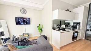 A modern apartment with a living room, a flat-screen TV, a kitchen with white cabinets, and a dining area. - Elite Skyline Suite, Ellipse, Waterfall City (Midrand)