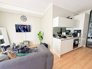 A modern apartment with a living room, a flat-screen TV, a kitchen with white cabinets, and a dining area. - Elite Skyline Suite, Ellipse, Waterfall City (Midrand)