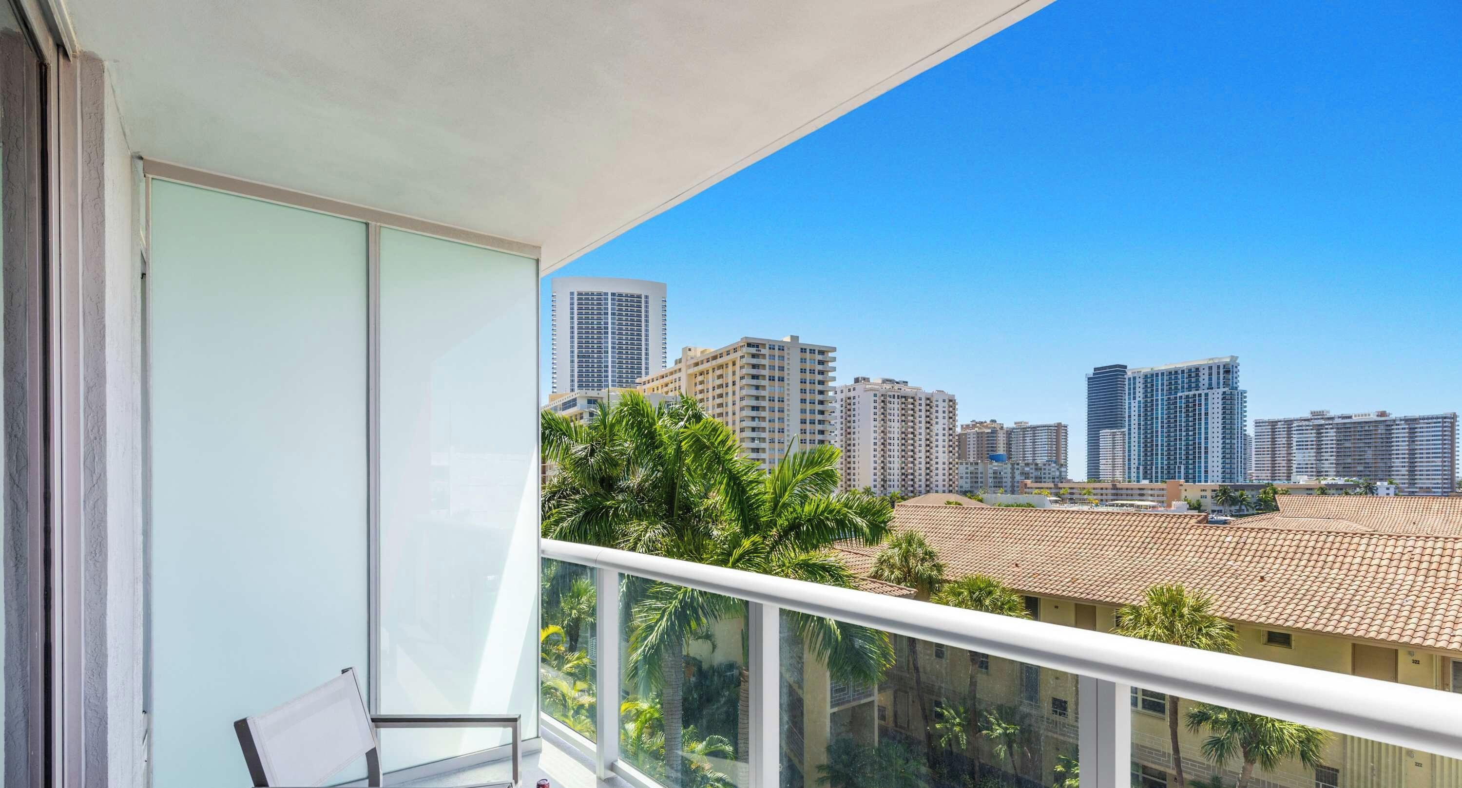 Un balcone con vista sulla città, che include grattacieli e palme.