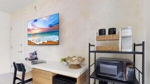 A kitchenette with a microwave, coffee maker, and wicker baskets on shelves. - Elevated Living - 2BR - Intracoastal Views (Hallandale Beach)