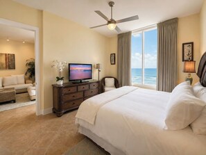 A hotel room with a large bed, a television, a ceiling fan, and a view of the ocean. - Sapphire 1605 - By GISO Vacation Rentals (South Padre Island)