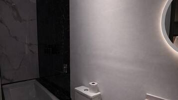 A modern bathroom with a toilet, sink, and bathtub.