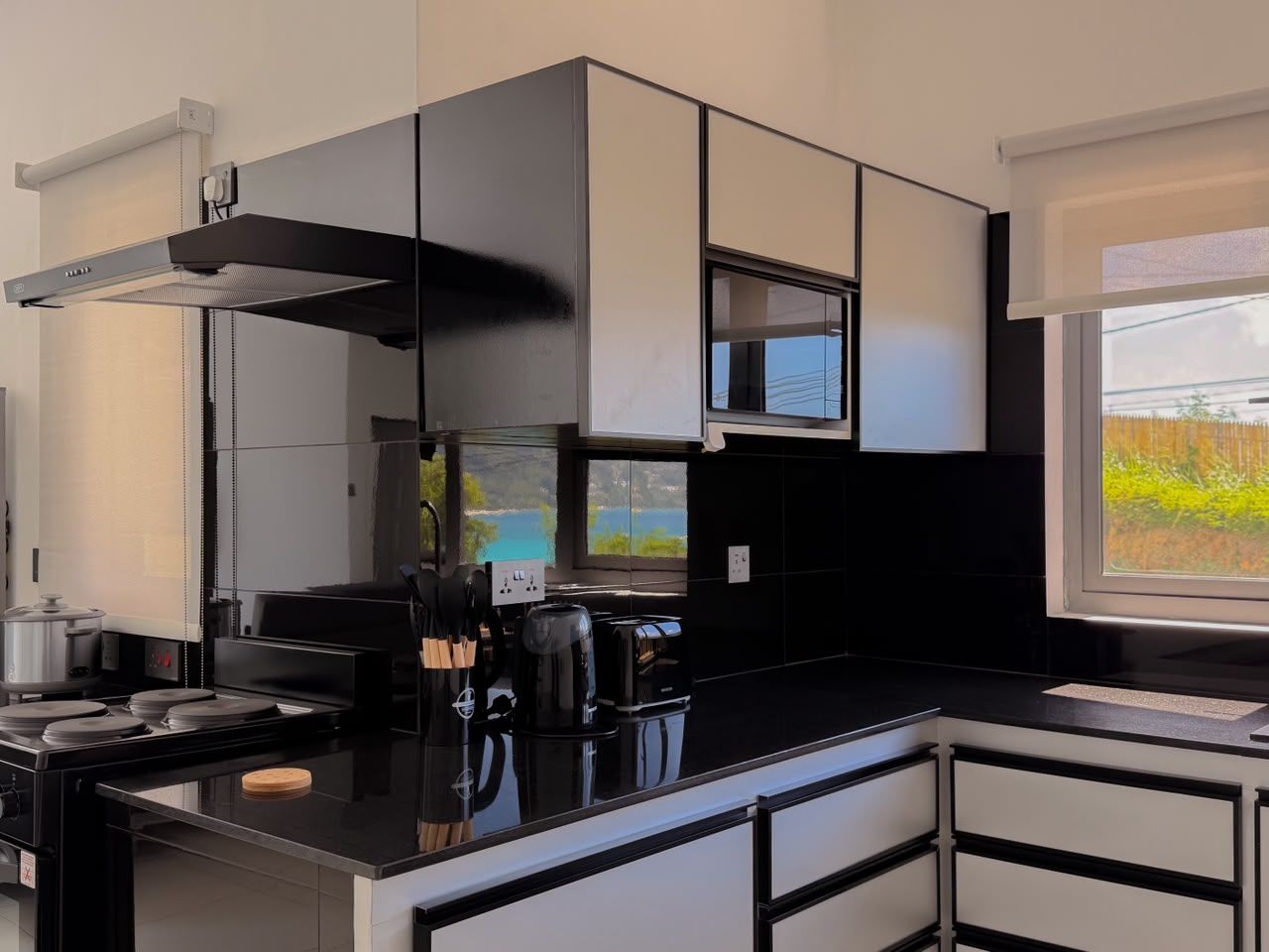 Una cocina moderna con estufa, microondas y cafetera.