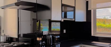 A modern kitchen with a stove, microwave, and coffee maker.