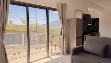 Ein modernes Wohnzimmer mit einer Couch, einem Flachbildfernseher und einer Schiebetür zu einem Balkon.