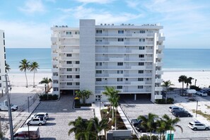 A multi-story hotel with balconies, a parking lot, and a beach view. - Gulf-Front Bonita Beach, FL Condo -  Private Beach Access + Pool / Gulf views (Bonita Springs)
