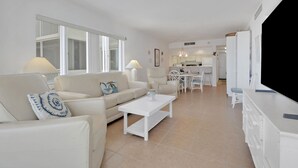 A modern living room with a sofa, coffee table, and a television. - Gulf-Front Bonita Beach, FL Condo -  Private Beach Access + Pool / Gulf views (Bonita Springs)
